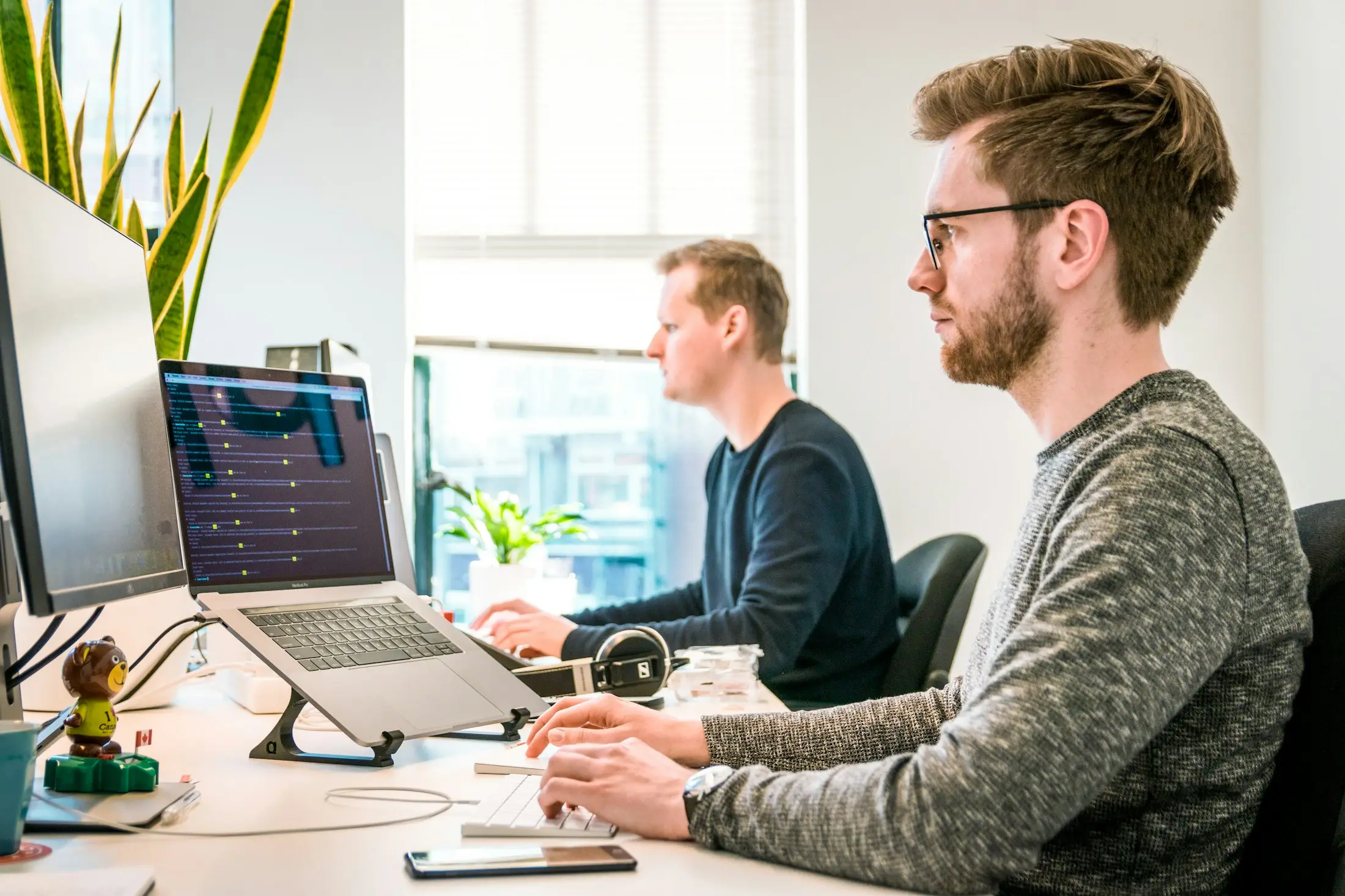 Techniciens travaillant sur des postes informatiques dans un bureau lumineux